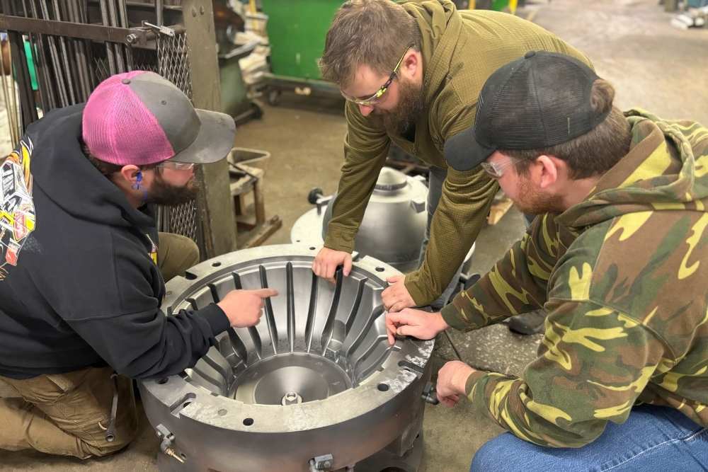 image of Alcast Company engineers inspecting an aluminum casting